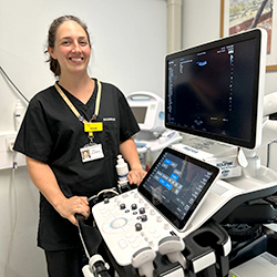 Trish, a sonographer at the RUH, standing next to an ultrasound machine