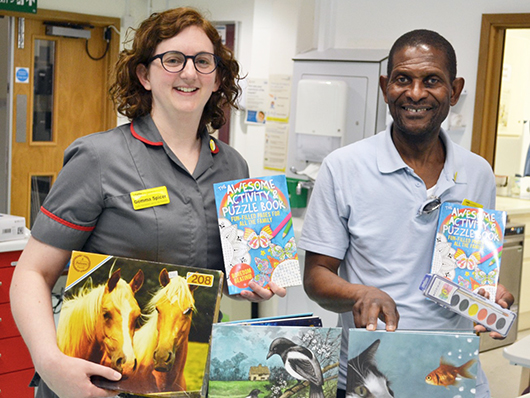 Gemma Spicer and Silas Mtisika holding activity packs