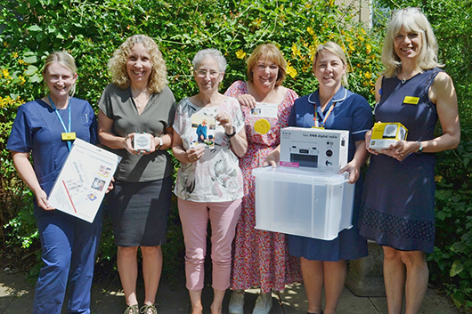 Rob Brown's family and RUH staff holding the typical contents found in Bob's Boxes